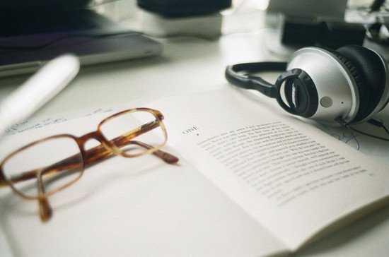 headphones, a book, and reading glasses