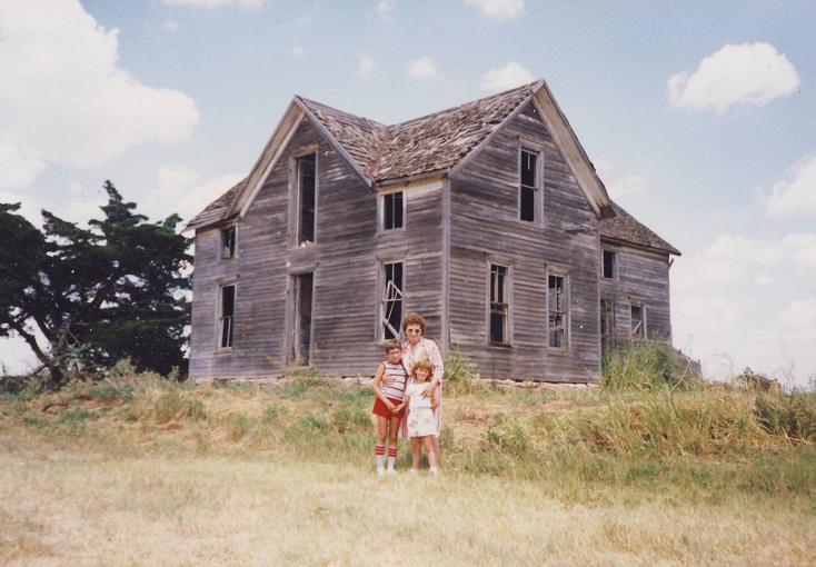 Benjamin Vogt with family, standing in front of the homestead (1980s)