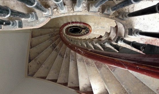 a top-down view of a spiral staircase with red bannister