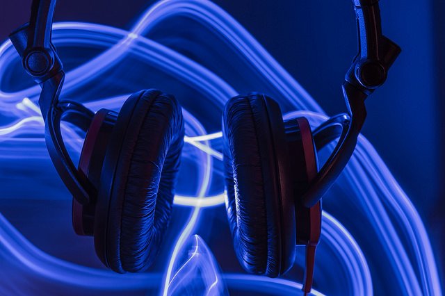 Headphones in front of purple luminescent waves
