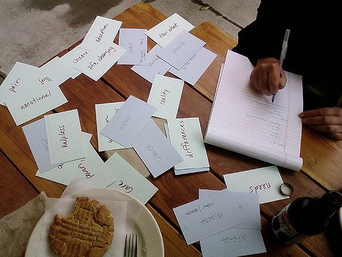 A person outlining ideas among various flashcards listing goals