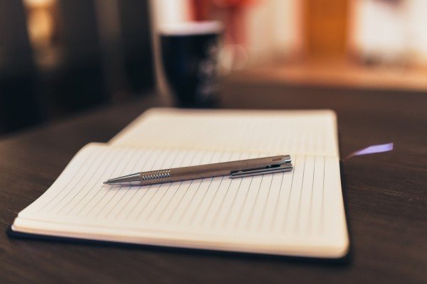 A pen resting on a blank journal page.