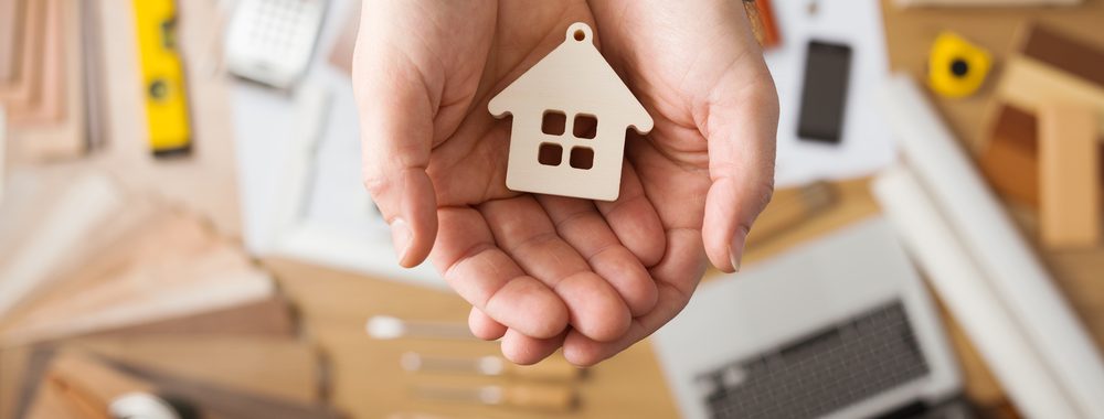 cupped hands holding small icon of a house