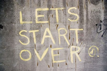 Image: urban wall with graffiti reading "Let's start over."