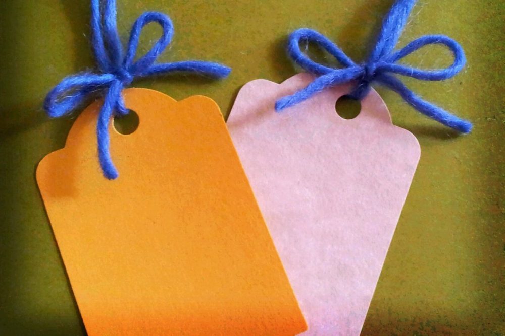 Image: blank gift tags tied to colorful yarn