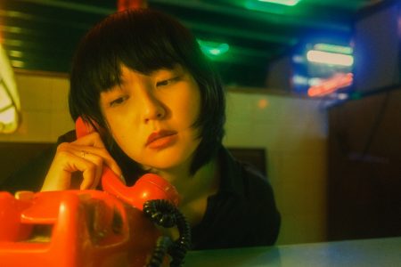 Image: young woman with a concerned expression, hold a telephone receiver.