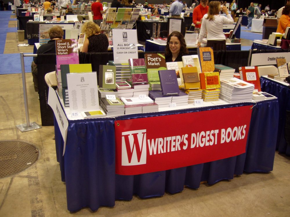 Image: Jane Friedman sitting behind piles of books at the Writers Digest Books table at the 2004 AWP conference.