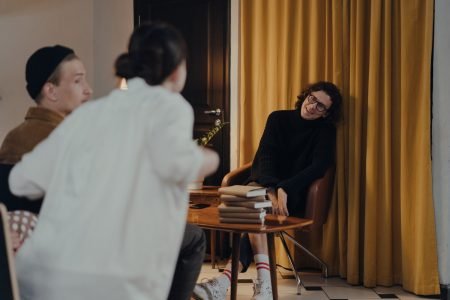 Image: a man at a book promotion event smiles while interacting with an audience member