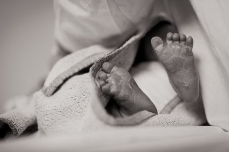 Image: black and white photo of a newborn baby's feet surrounded by swaddling.