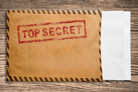 Image: two white sheets of paper peek out from a brown mailing envelope which is stamped "TOP SECRET" in red ink.