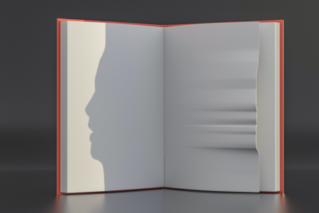 Image: A book without words in it stands open on a gray background. The page on the right contains a series of irregular creases causing the paper to have a warped profile at its edge. A stark light shining against it from the right side throws a shadow onto the left page of the book, where the creased edge reveals itself to be the profile of a human face.