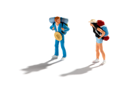 Image: Miniature hand-painted figures of a woman and man, both wearing hiking gear, are set on a stark white background.