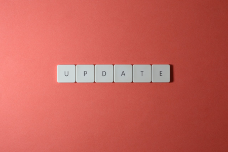 Image: lettered white tiles on a red background spell the word "Update."