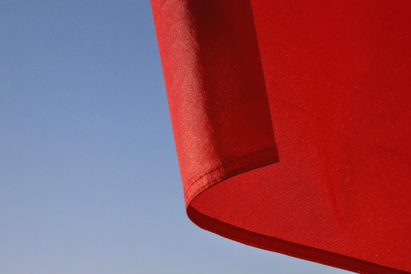 Image: a red flag against a blue sky