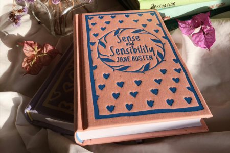 Image: a clothbound edition of Jane Austen's Sense and Sensibility is arranged with other books and dried flowers.