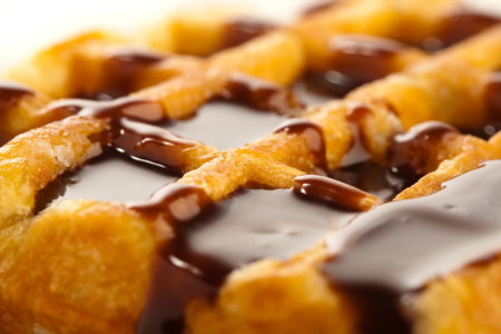 Image: close-up photo of a waffle covered with chocolate sauce