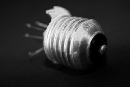 Image: the base of a lightbulb from which the glass bulb has been broken and is missing.