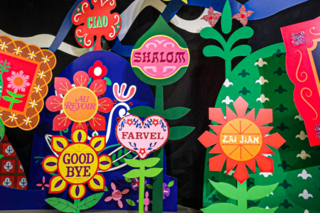 Image: From the end of Disney's Small World ride, a group of highly-decorated and brightly-colored signs reading "Good bye" in different languages.