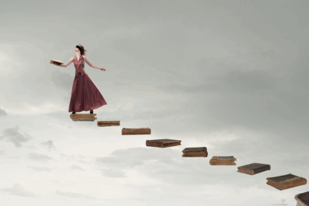 Image: a series of antique hardcover books float in the air, creating a stairway. Standing on the topmost book is a blindfolded woman wearing a red dress, holding an open book in one hand, and with her head turned upward as if in the direction of the stairway's eventual path.