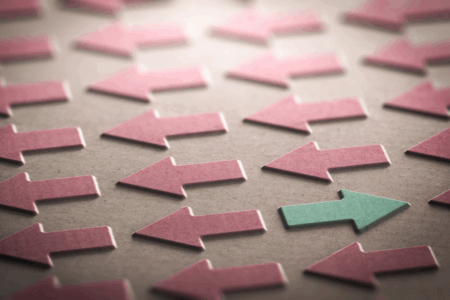 Image: embossed in a piece of heavy paper are many rows of red arrow facing left, amid which is a single green arrow facing right.