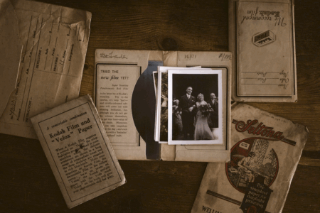 Image: a black and white wedding photo sits atop a stack of other antique photos amid vintage Kodak film envelopes.