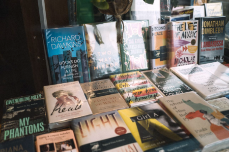 Image: hardcover books are displayed in a bookstore window
